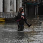 Pariskunta kahlasi Venetsiassa 8. joulukuuta 2020 korkeiden tulvavesien lomassa. 