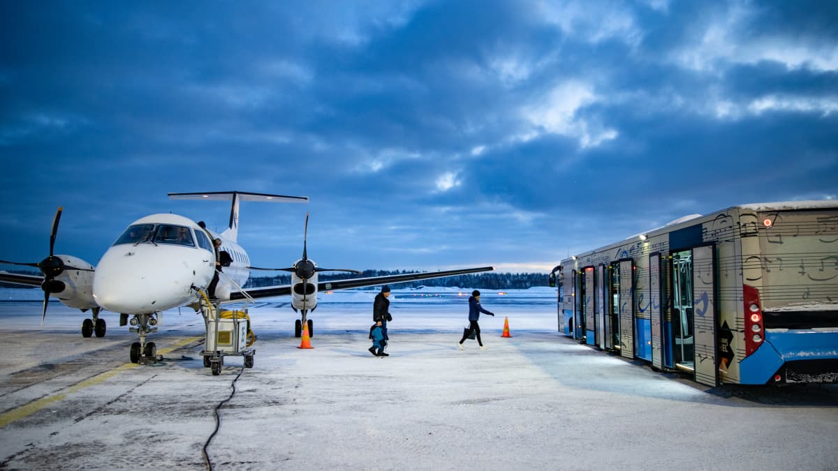  Porista saapuneen lentokoneen matkustajia Helsinki-Vantaan lentokentällä siirtymässä yhteysbussiin.