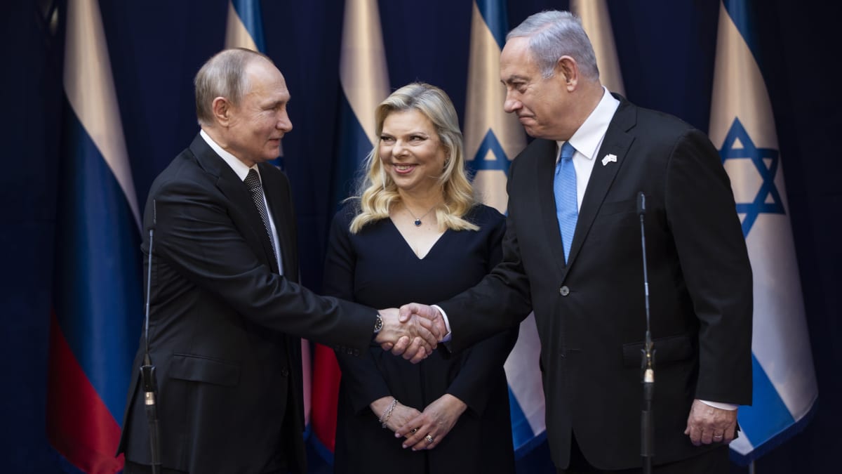 Venäjän Vladimir Putin ja Israelin Benjamin Netanjahu kättelevät. Välissä seisoo Netanjahun puoliso Sara Netanjahu.