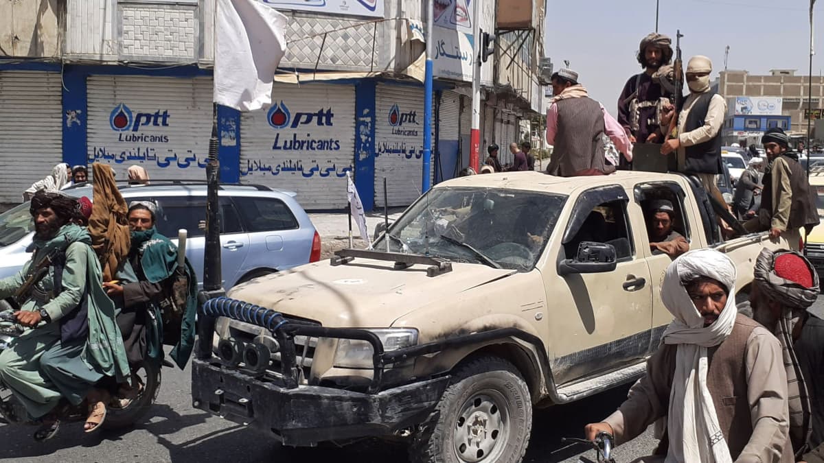 Taliban -taistelijat ajavat autolla.