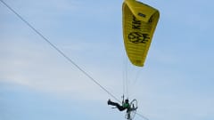 Greenpeace-aktivisti lentää moottoroidulla varjoliidolla.