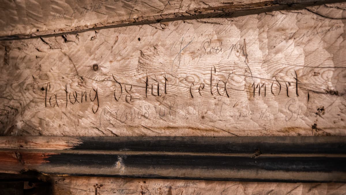 Karvian kellotapulin vanhaan seinähirteen kaiverrettu teksti, jossa lukee ilmeisesti La fang tut ce la mort. Siinä voi myös lukea La tang tut ce la mort. Ja tut sanaa ennen on kaiverrettu mahdollisesti numerot 08.