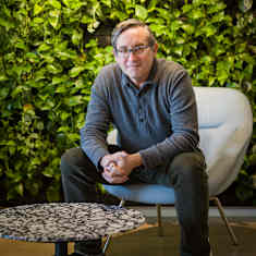 Tom Hale istuu tuolilla viherseinän edessä.