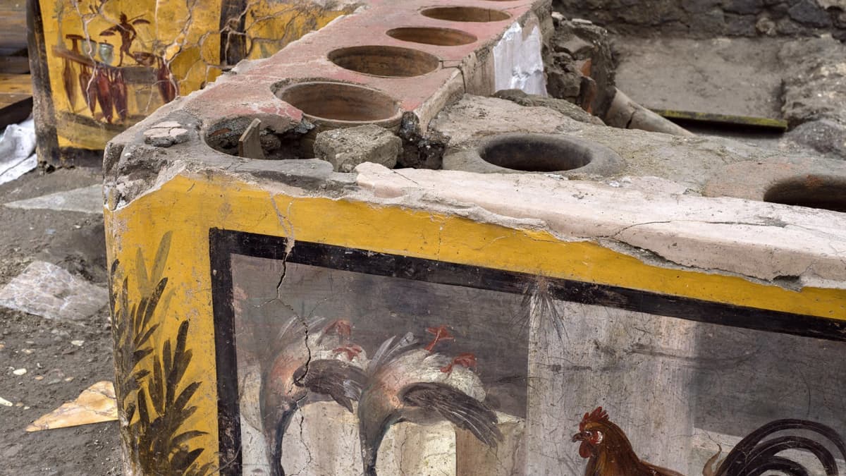 Monivärisesti ja taidokkaasti koristeltu katukeittiön tiski Pompeijissa.