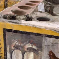 Monivärisesti ja taidokkaasti koristeltu katukeittiön tiski Pompeijissa.