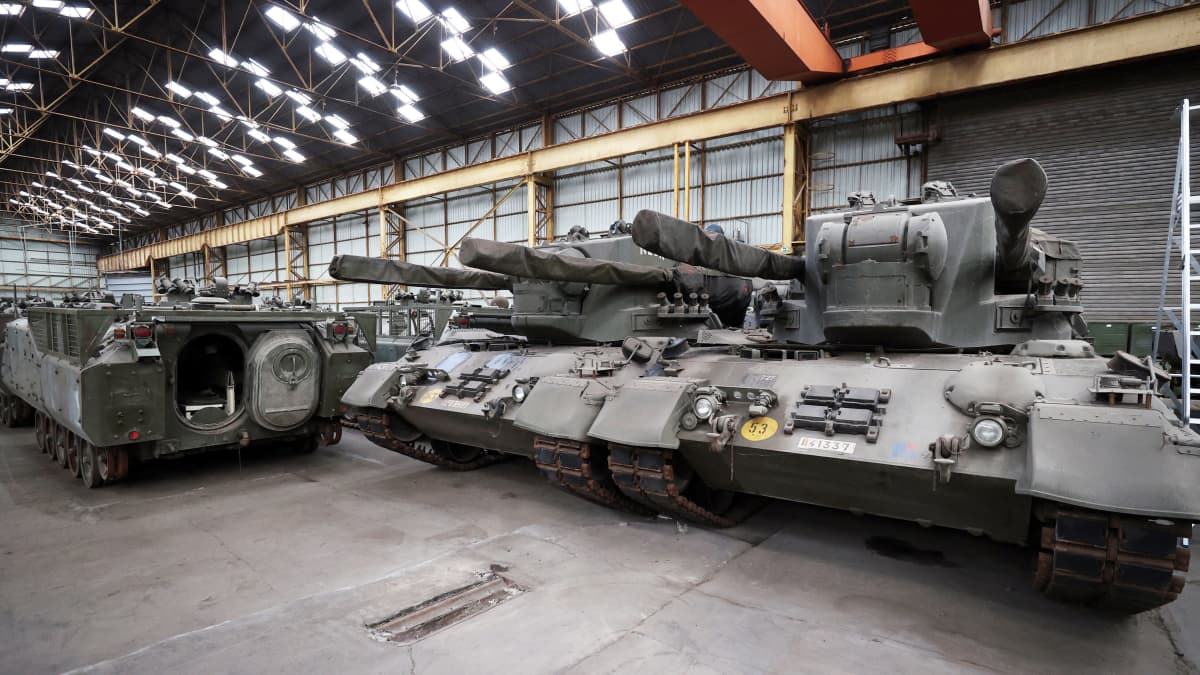 Leopard 1-stridsvagnar står på rad i ett lagerutrymme.