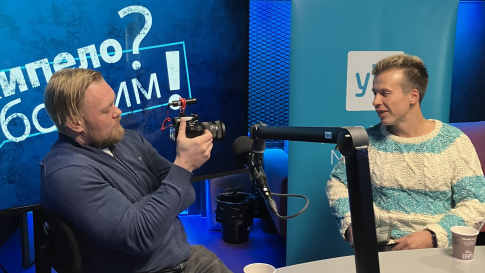 kaksi miestä radiostudiossa, toinen kuvaa kameralla toista.