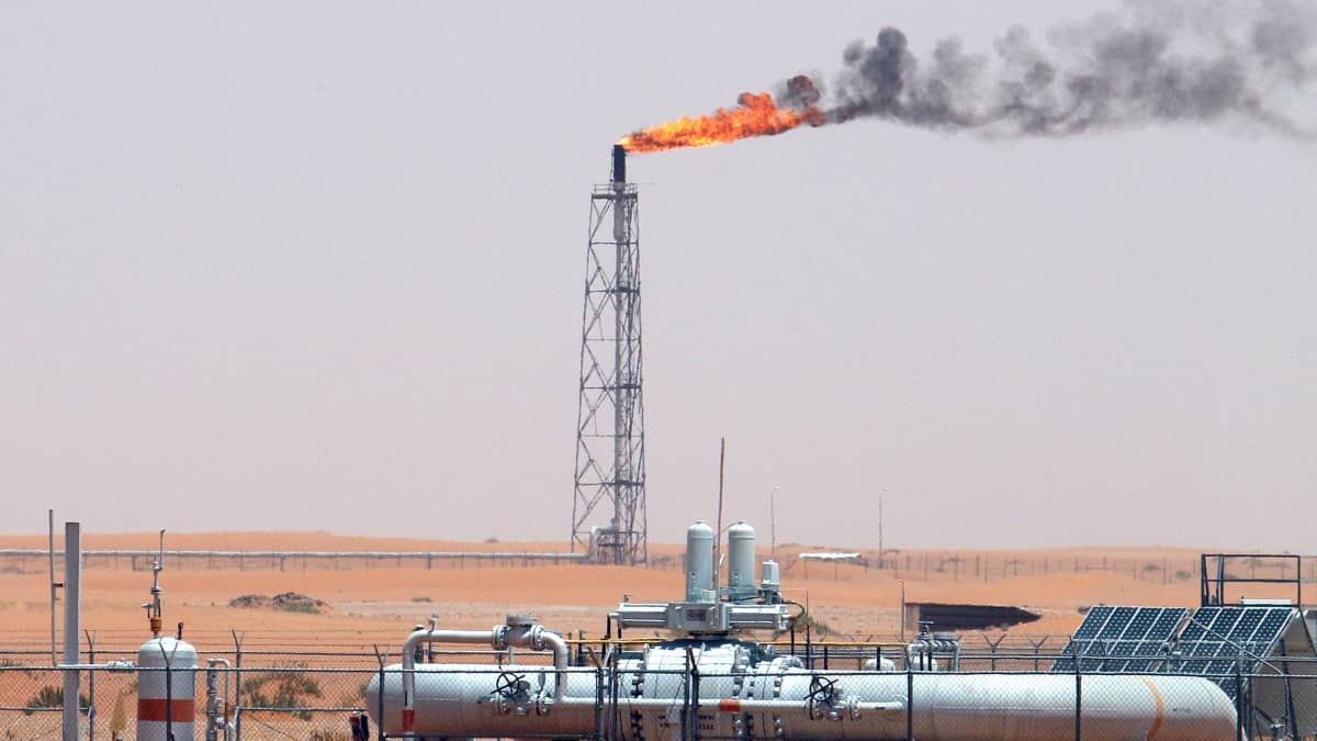 Saudiarabialainen öljykenttä. Poraustornista nousee liekkejä.