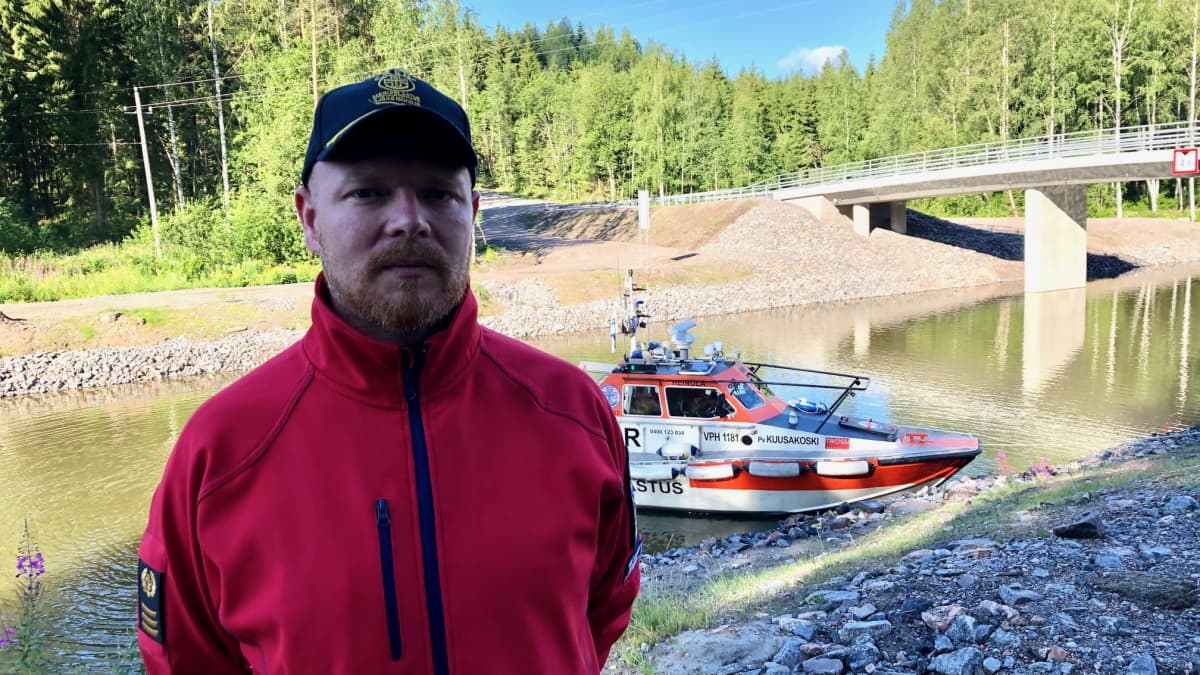 Heinolan järvipelastajien puheenjohtaja Sami Salomaa seisoo Kimolan kanavan varrella takanaan yhdistyksen Kuusakoski -pelastusvene.
