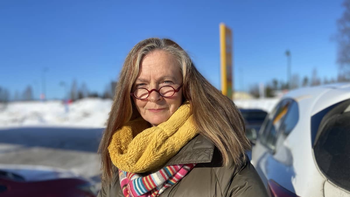 Vihreiden kansanedustaja Heli Järvinen seisoo autonsa vieressä.
