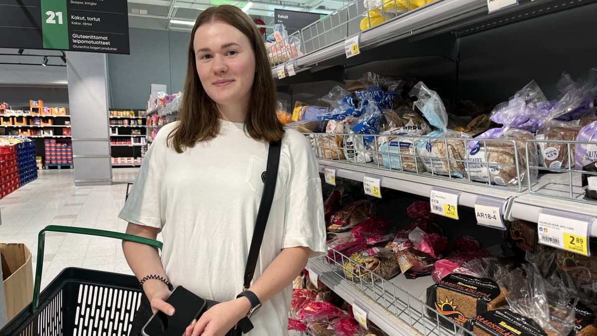 Helsinkiläinen Maria Smirnova Prisman leipätiskin luona, kori kädessään.