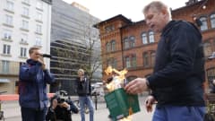 Kolme miestä kuvaa Koraanin tuleen sytyttänyttä Rasmus Paludania.