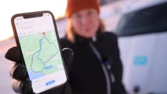 Toimittaja näyttää kameralle puhelinta, jossa näkyy Google Mapsin reittivaihtoehdot välillä Oulu–Rovaniemi.