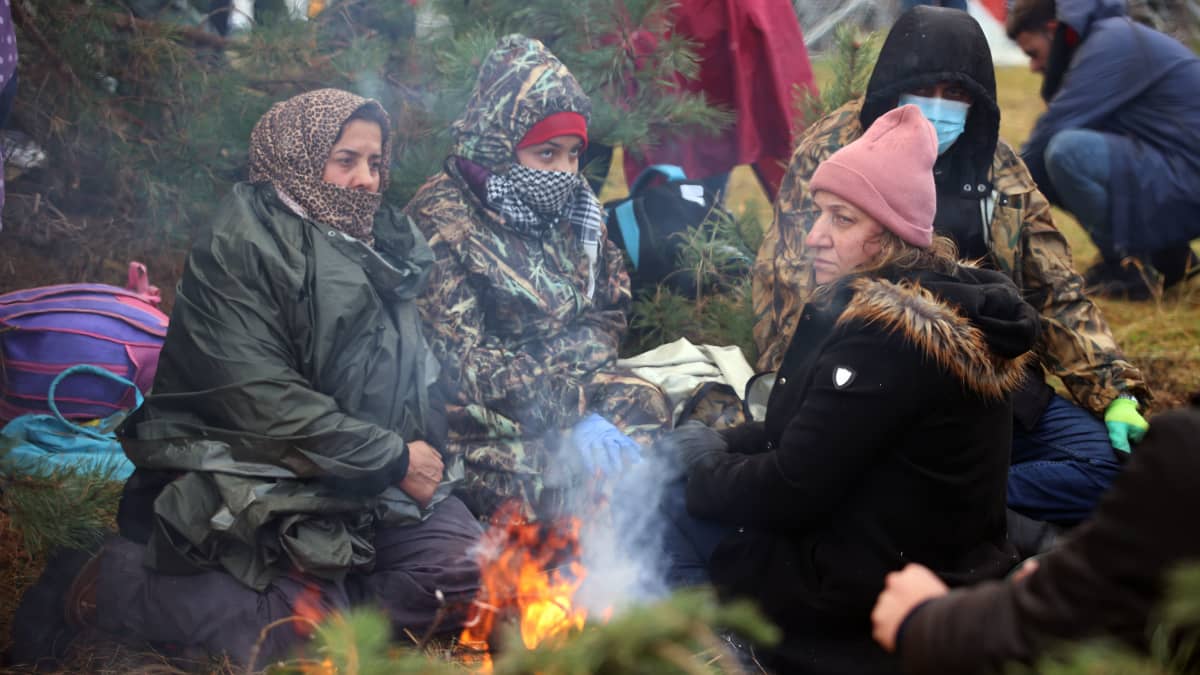 Naisia lämmittelemässä nuotion äärellä Valko-Venäjän ja Puolan rajalla.