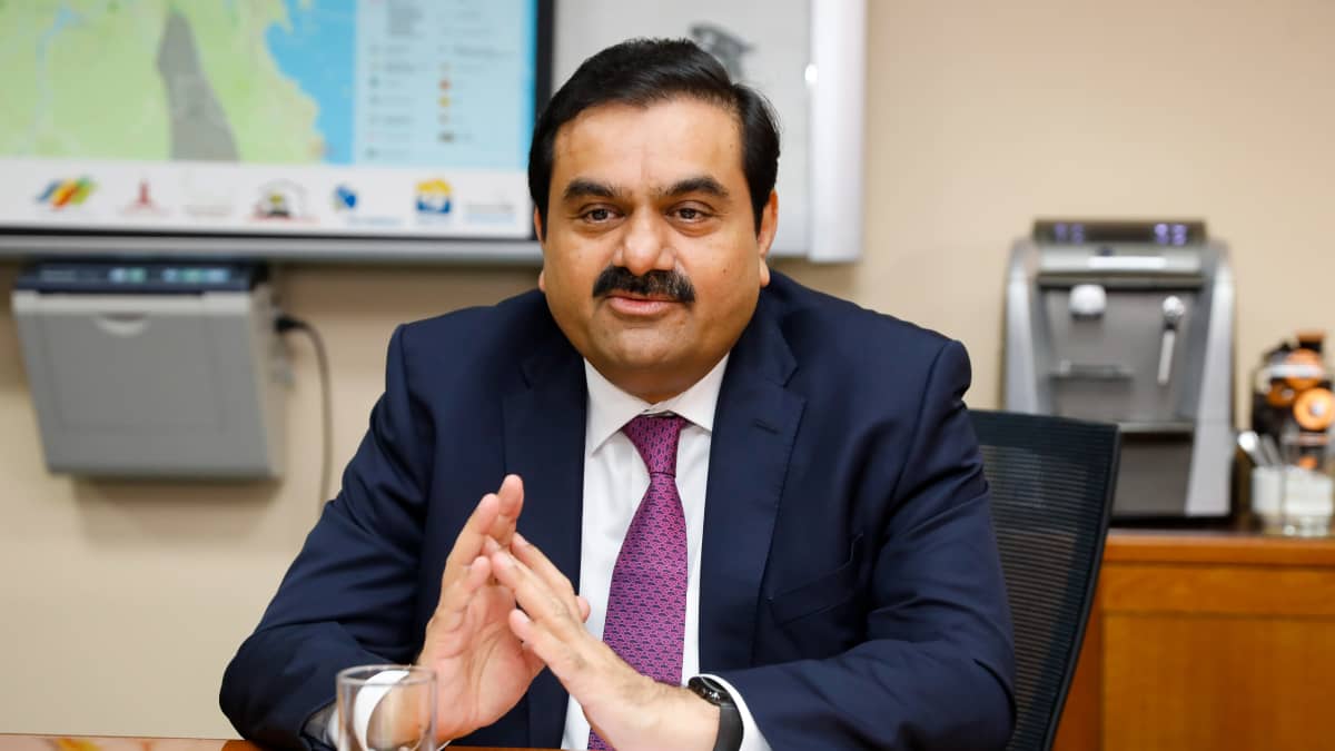 Adani Groupin Gautam Adani istuu pöydän ääressä.