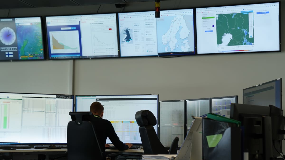 Fortum, analyysi- ja tarkkailutiloissa henkilö istuu monitorien edessä työpöytänsä ääressä hieman eteenpäin kumartuneena.