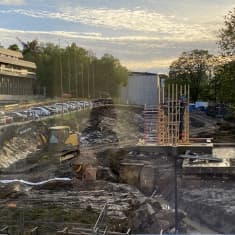 Entisen itsenäisyydenaukion tontti on kaivettu lähes tyhjäksi. Kuva otettu syyskuussa 2023. Keskellä kuoppaa on keltainen kaivuri. Taustalla näkyy Wäinö Aaltosen museon valkoinen päätyseinä. Kuvan vasemmassa laidassa on Turun virastotalon ruskea seinä ja julkisivun ikkunat.