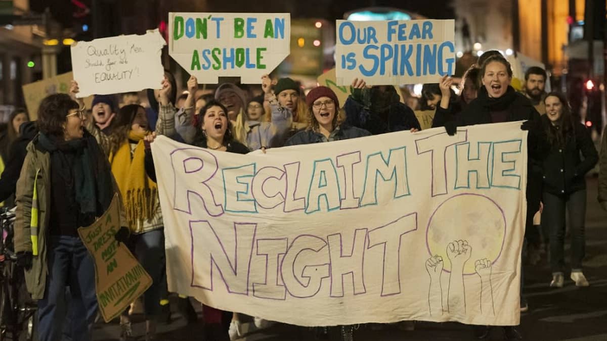 Nuoria naisia mielenosoituksessa, jonka englanninkieliset kyltit vaativat naisille oikeutta yöelämään. Yksi kylteistä kertoo huumaamisen pelosta. 