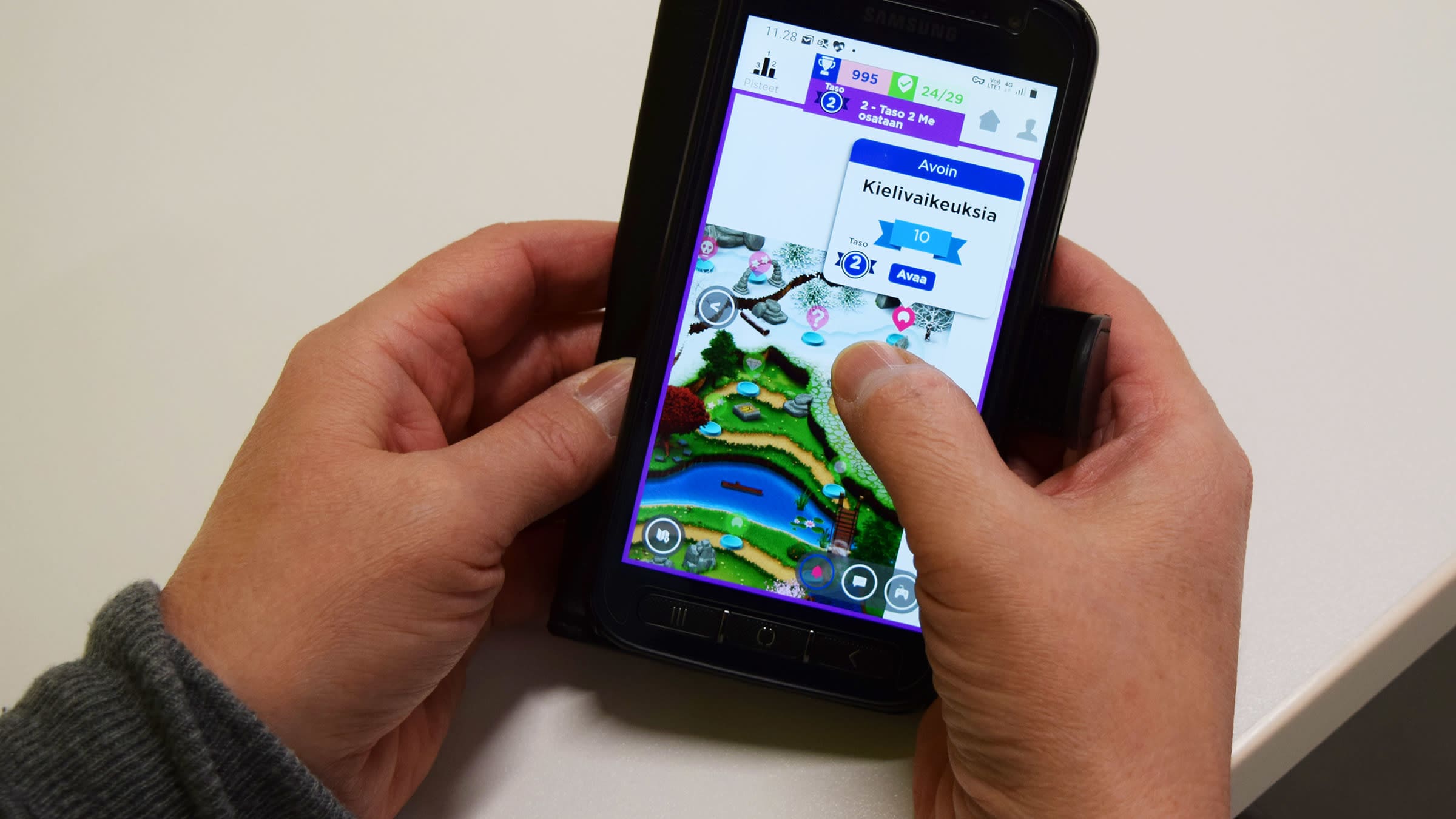 Värikäs Seppo-peli älypuhelimen näytöllä ihmisen käsissä. 
