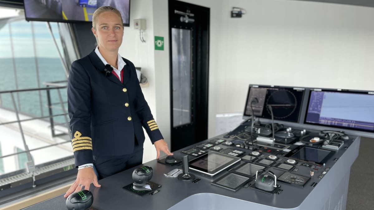 Naiskapteeni laivan komentosillalla ohjauspöydän ääressä