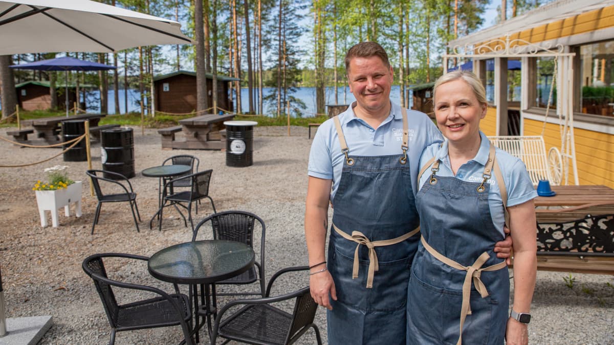 Jukka Vuorela ja Minna Luoma-aho poseeraavat leirintäalueen pihalla.