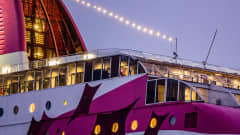 Matkustaja-autolautta Baltic Princessin peräosa lähikuvassa. Sen valkoisessa kyljessä on kuvioita pinkillä värillä. 