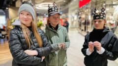 Kolme yläkoulun opiskelijaa seisoo kauppakeskuksen käytävällä