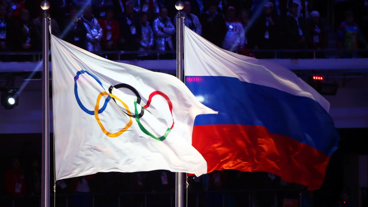 Olympialaisten lippu ja Venäjän lippu liehuvat vierekkäin.
