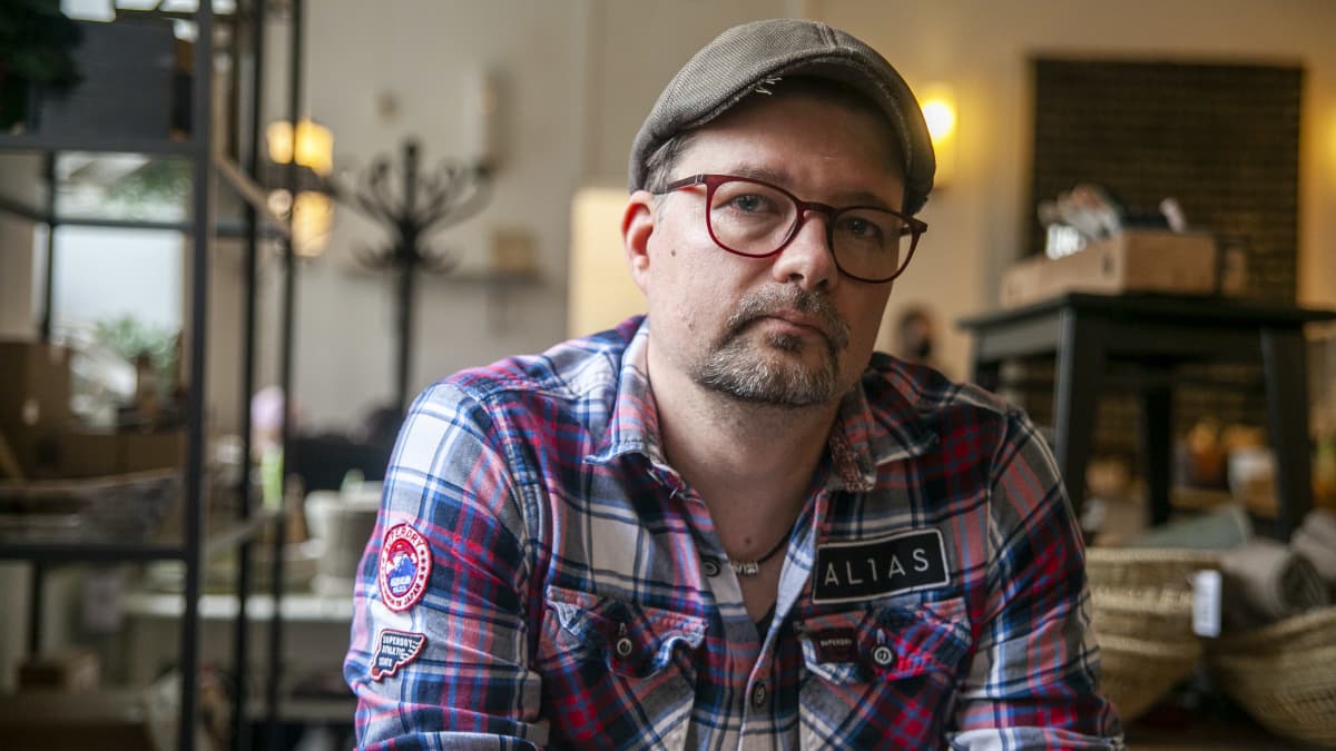 Antti Karppinen, valokuvaaja, istumassa Kuopion junaasemalla olevassa kahviossa