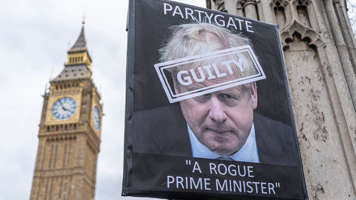 Boris Johnsonin kasvot mielenosoittajan kyltissä, Big Benin ulkopuolella Lontoossa. 