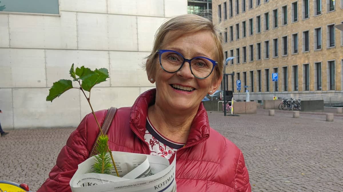 Anita Ventelä sylissään kuusen, männyn ja koivun taimet.