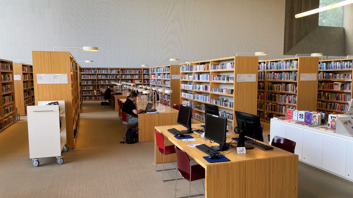 Seinäjoen Apila-kirjaston sisätiloja, ihmisiä lukemassa. 