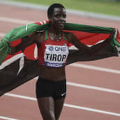 Agnes Tirop Kenian lippu harteillaan urheilusuorituksen jälkeen.