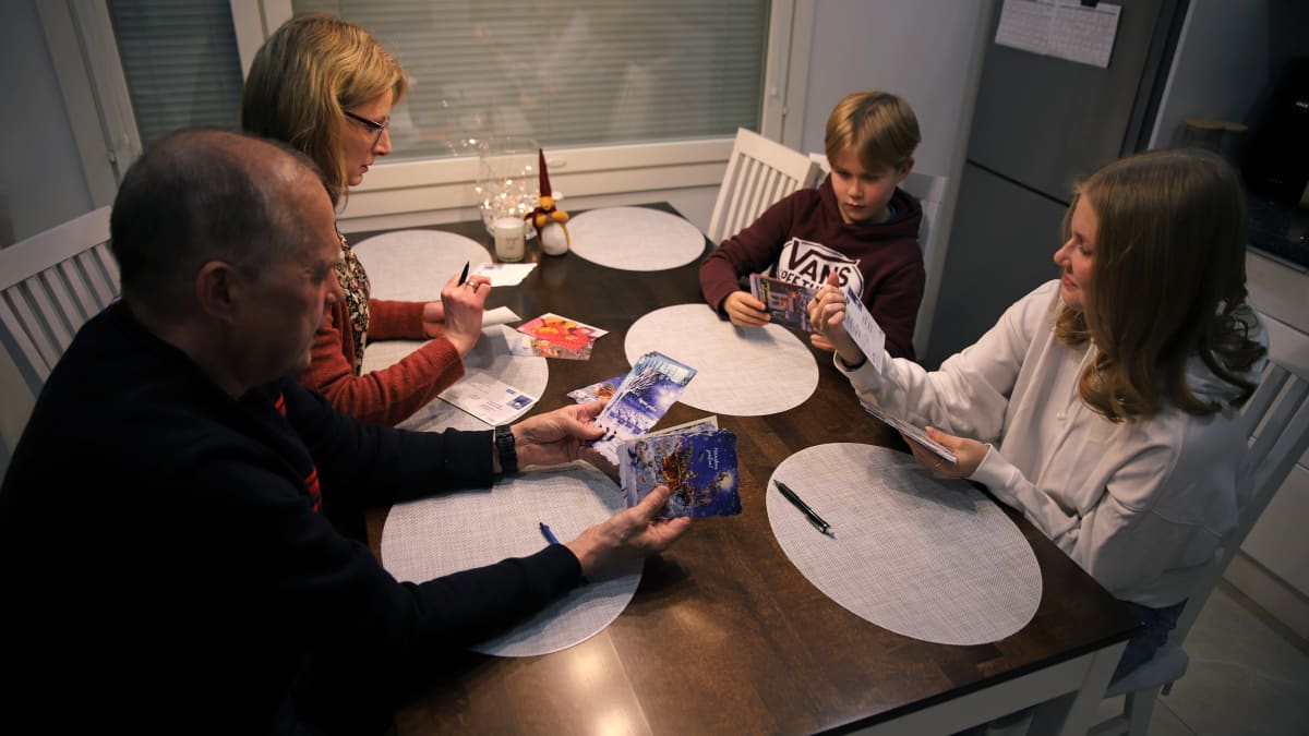 Qvintuksen perhe kirjoittaa joulukortteja keittiössään.