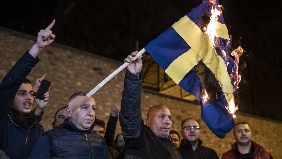 Miesjoukko polttaa Ruotsin lippua
