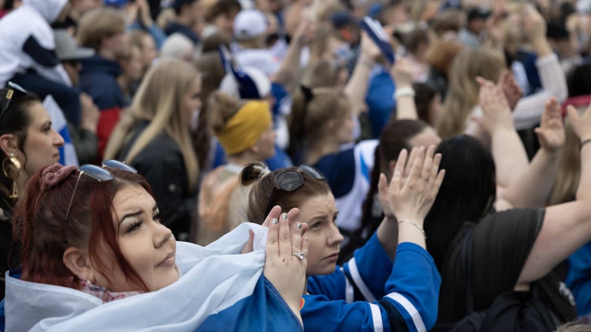 Lähikuvaa ihmisistä kultajuhlissa, kaikki taputtavat.