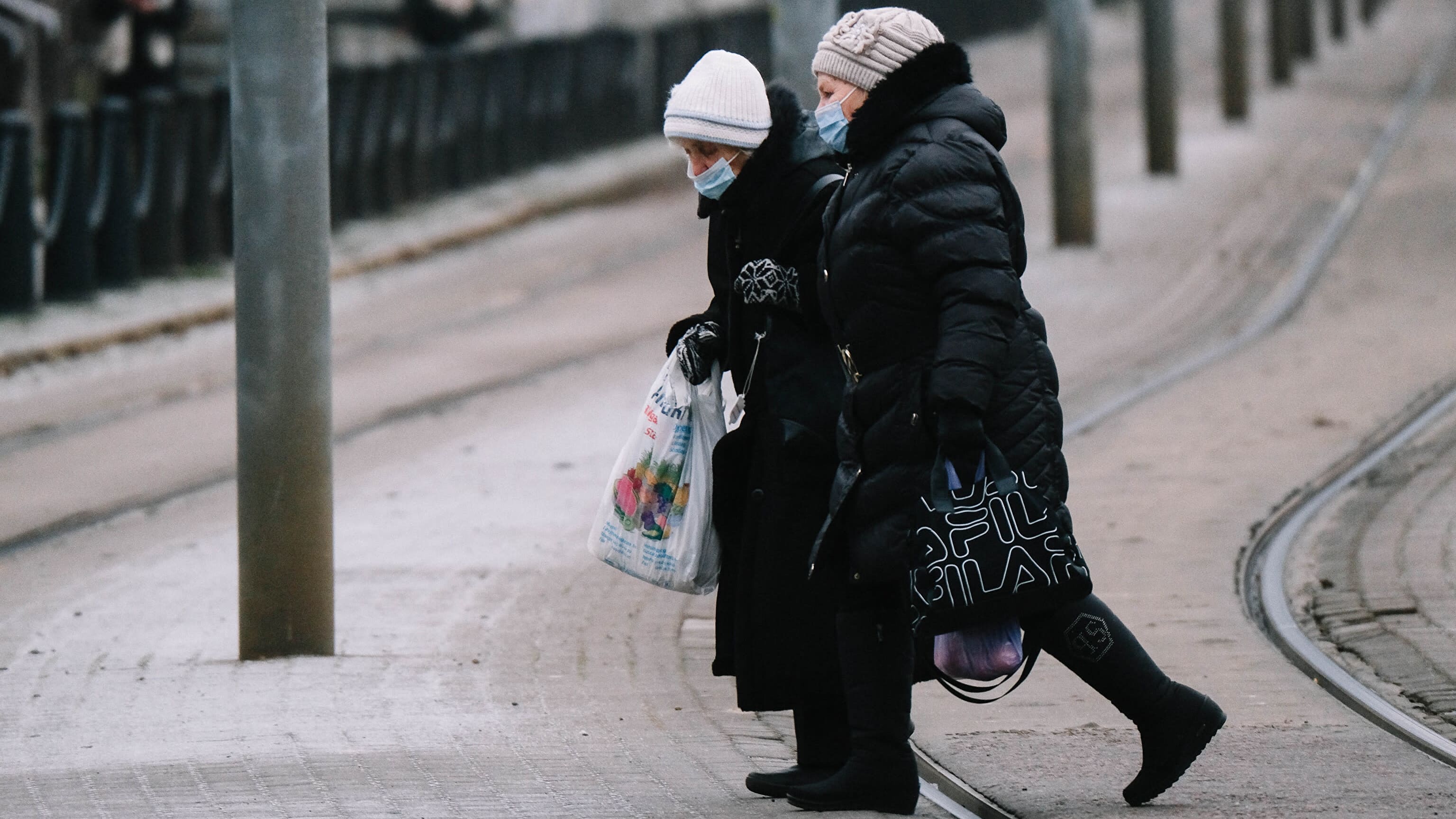 Virolaisia eläkeläisiä ylittämässä raitiovaunun raiteita Tallinnan keskustassa