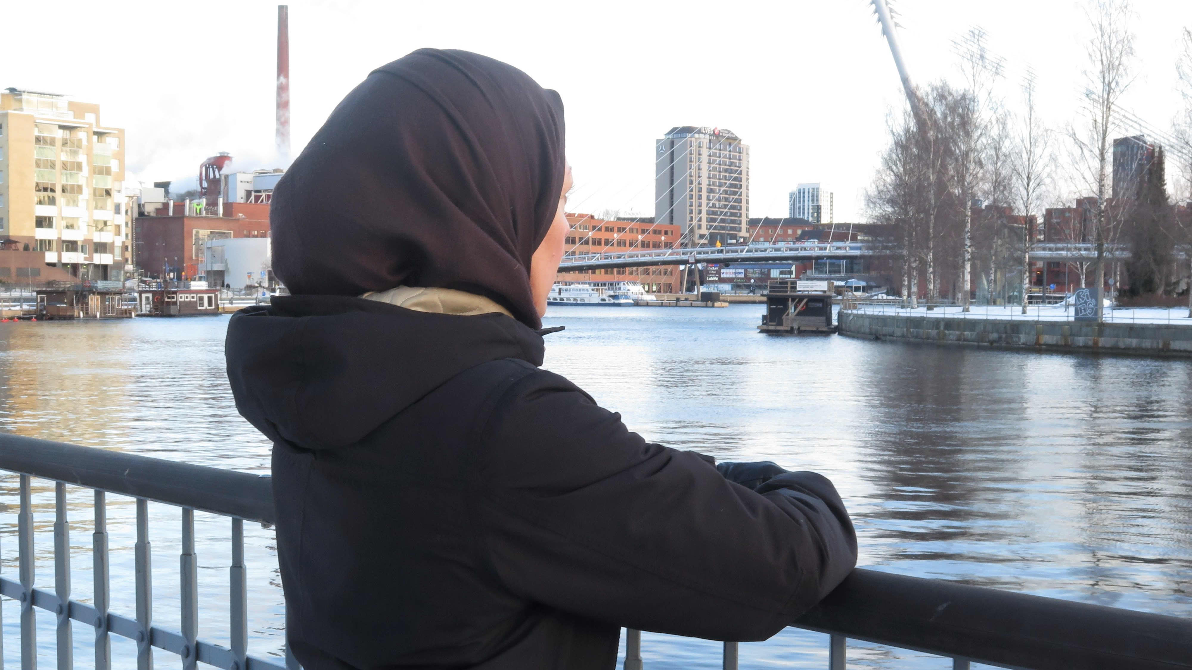 Kunniaksi-hankkeen projektityöntekijä Doaa Al-Shmes Setlementti Tampere ry:stä nojaa kaiteeseen Tammerkosken rannalla.