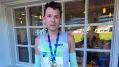 Leonid Latsepov stands with a medal after finishing the half marathon. 