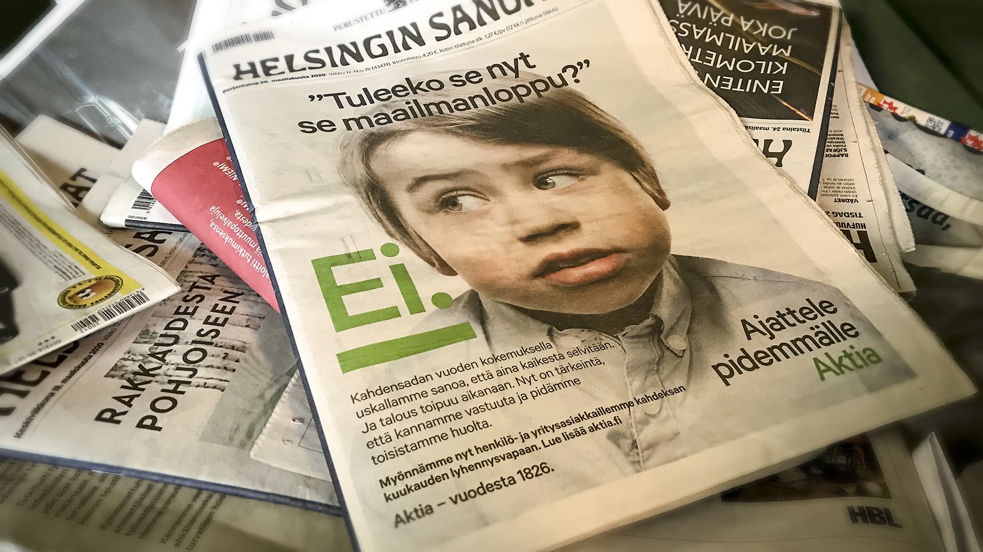 Aktia pankin mainos Helsingin Sanomien kannessa, lehti lehtilaatikossa päälilmmäisenä.