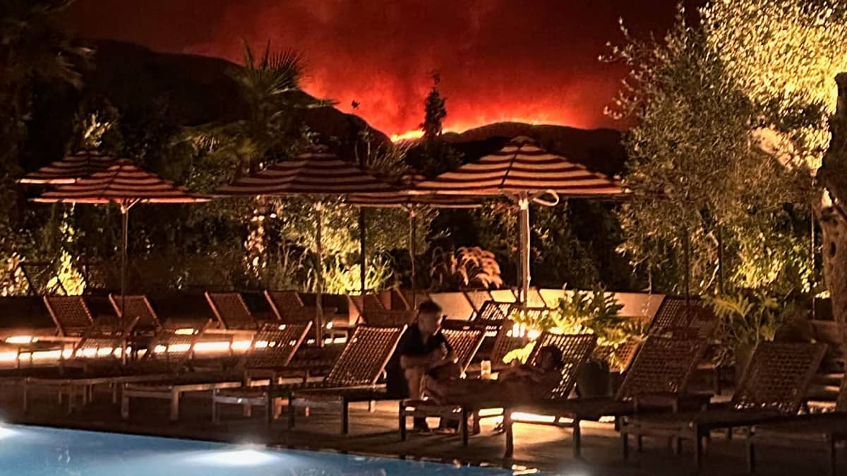 Etäällä raivoavat metsäpalot näkyvät hotellin uima-altaalle Korfun saarella Kreikassa.