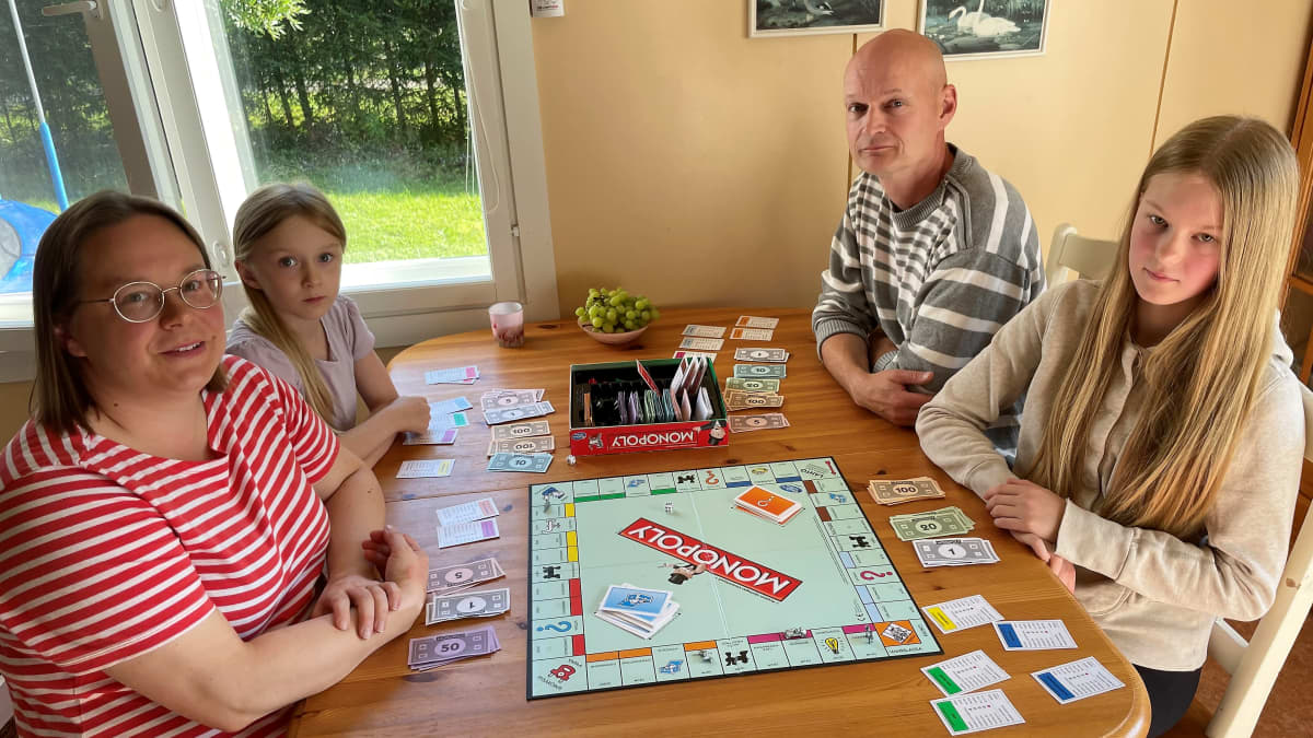 Kaisa Kurikkala,  Aila Manninen, Iida Manninen ja Tero Manninen istuvat perheen kotona Montolan kylässä pöydän ääressä pelaamassa Monopoly-lautapeliä. 
