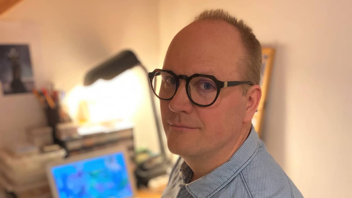 Agemonia-lautapelin suunnitellut Max Wikström istuu pyöreäsangaiset silmälasit päässä kannettavan tietokoneen äärellä