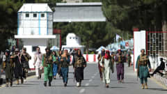 Talibankrigare promenerar vid huvudingången till Kabuls flygplats.