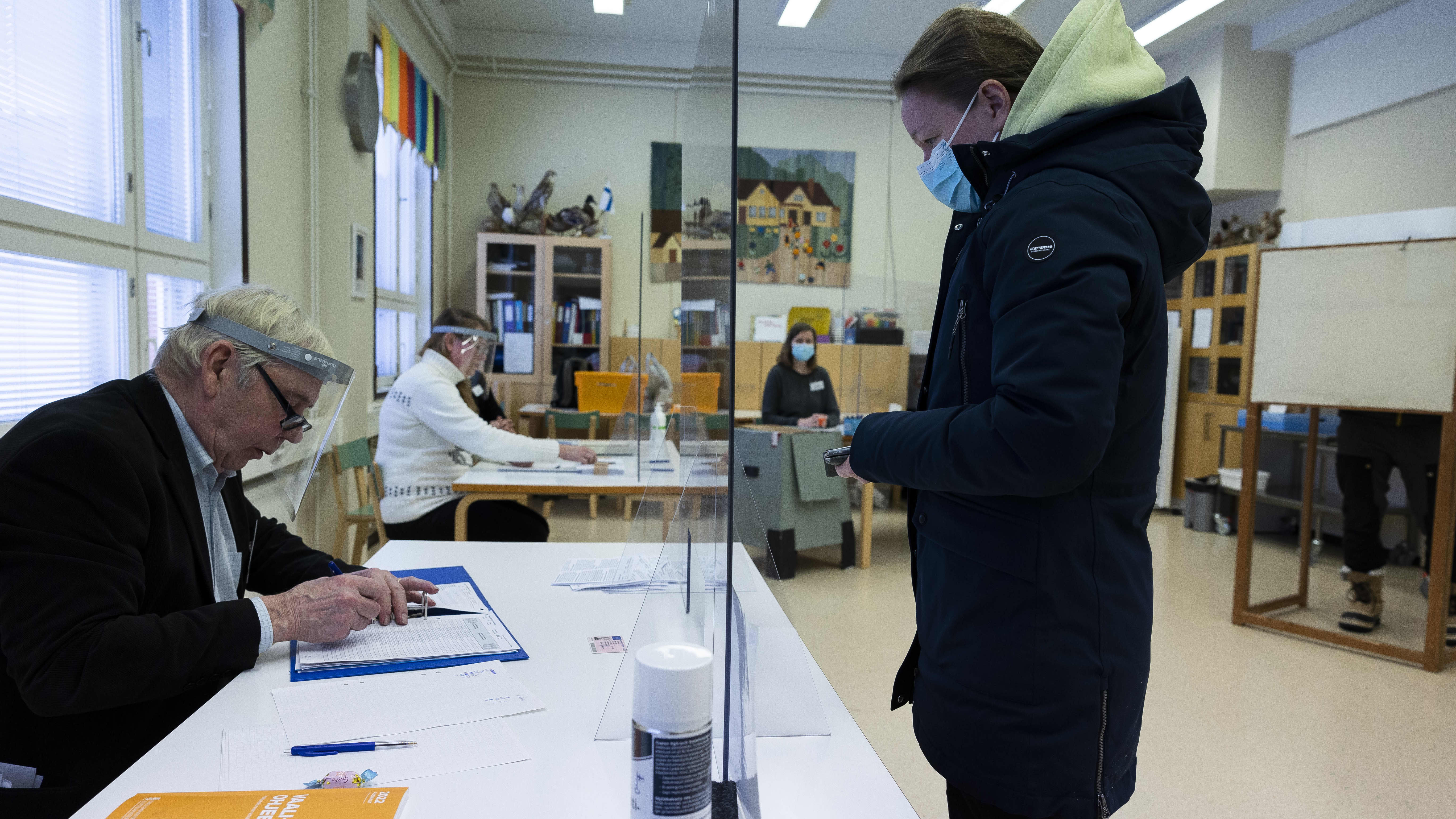 Vaalivirkailija tarkastamassa äänestäjän henkilöllisyyttä.