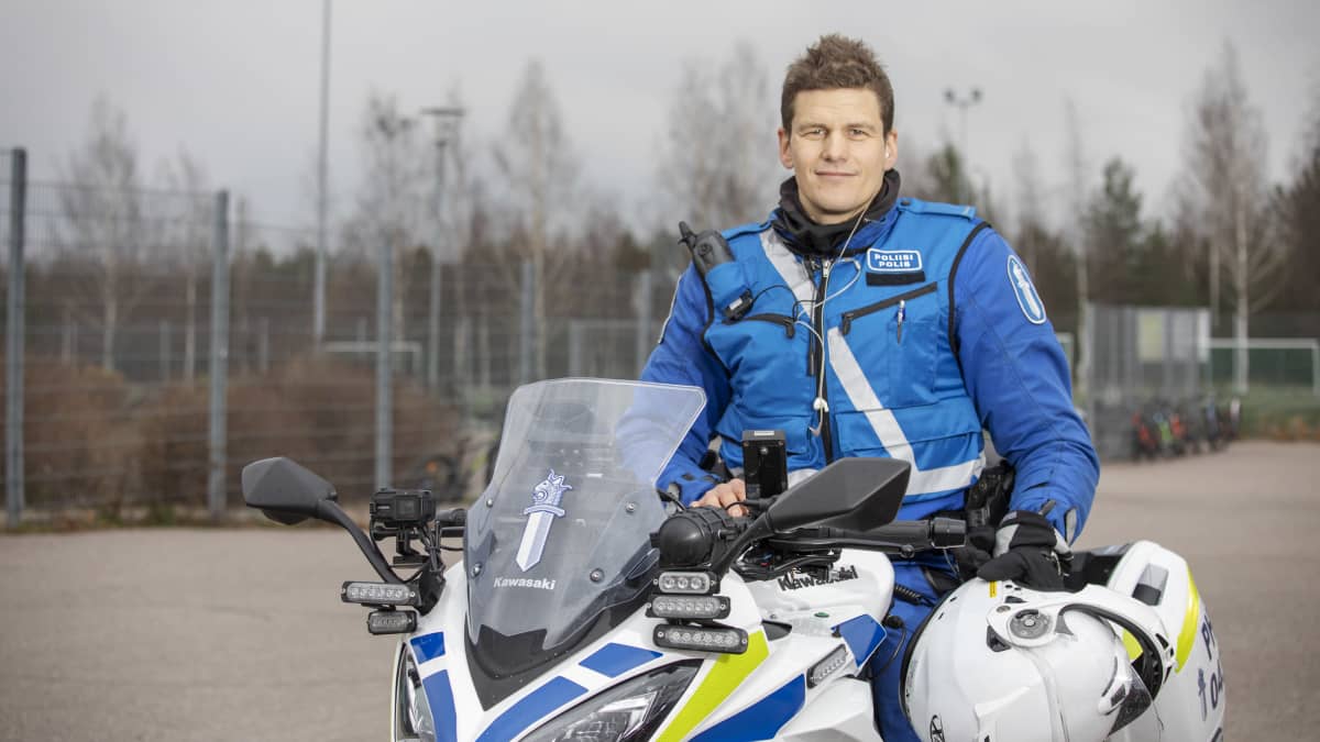 Vuoden poliisi 2021 Teppo Rainio istuu poliisimoottoripyörän kyydissä ja hymyilee.