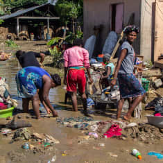 Haitilaiset raivaavat tavaraa kadulta tulvan jäljiltä Leoganessa. 
