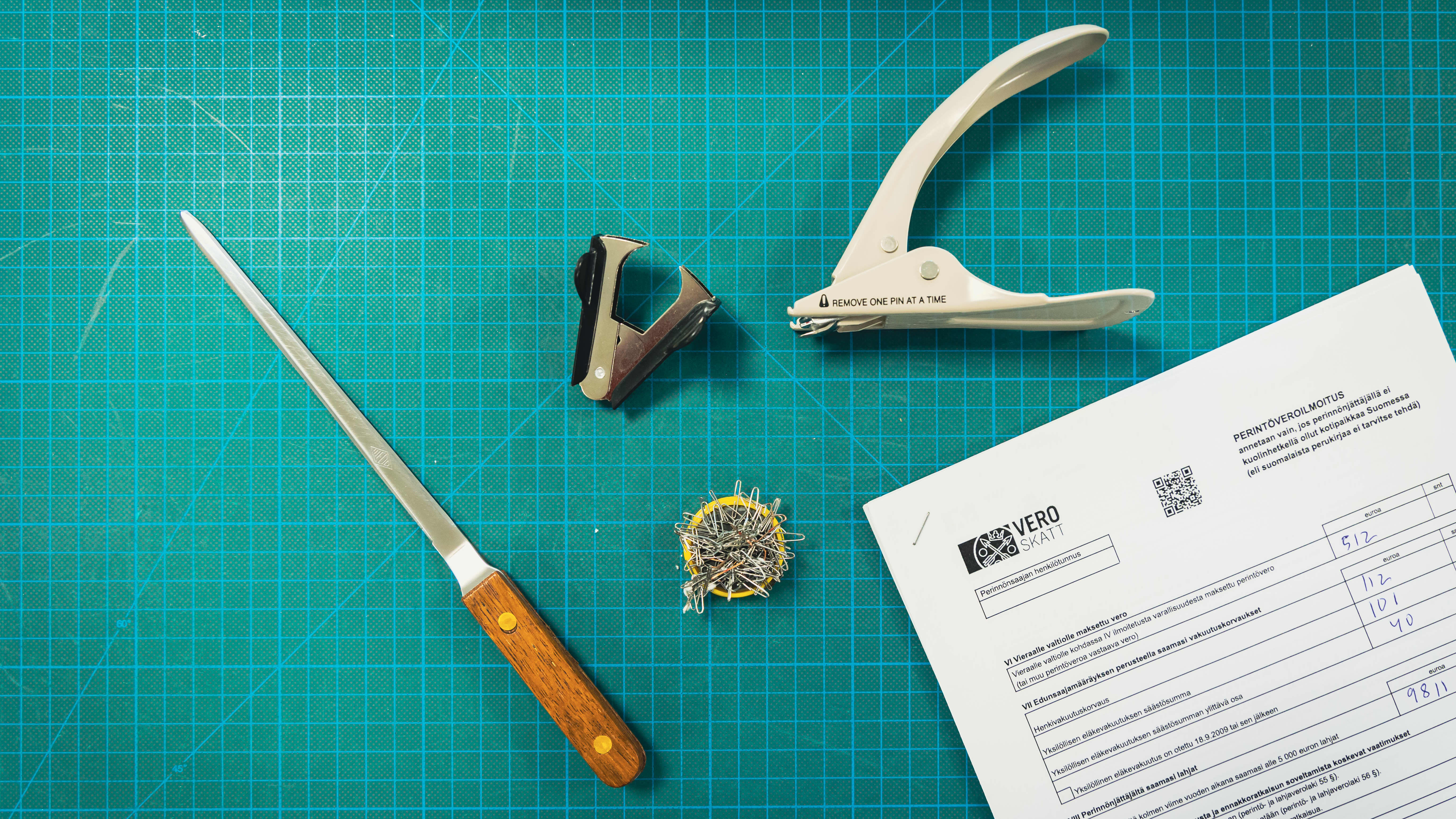 Kansallisarkiston työkaluja joita käytetään niittien poistoon asiakirjoista.