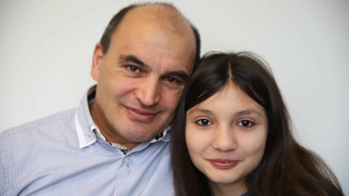 Isä ja tytär, Kurbanbek Ikrombekov ja Karina Ikrombekova hymyilevät kameralle.