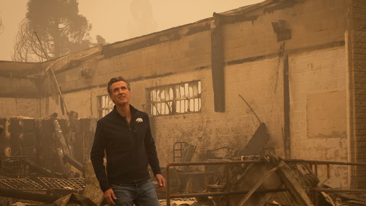 Kalifornian kuvernööri Gavin Newsom seisoo palaneen rakennuksen edessä Kalifornian Greenvillessä.